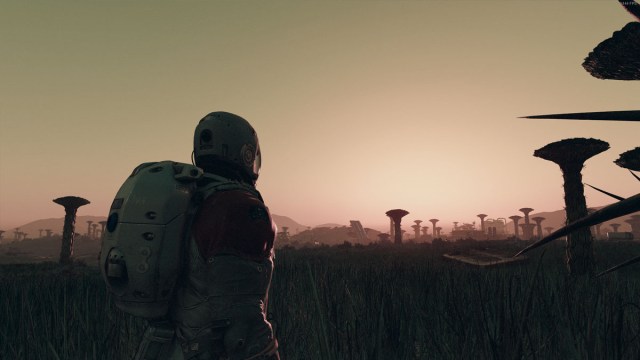 A starfarer in a space suit stands next to a cactus-like tree as the sun sets over a savannah landscape in Starfield