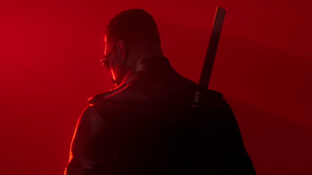 Blade standing in the red background with his back turned to the camera.
